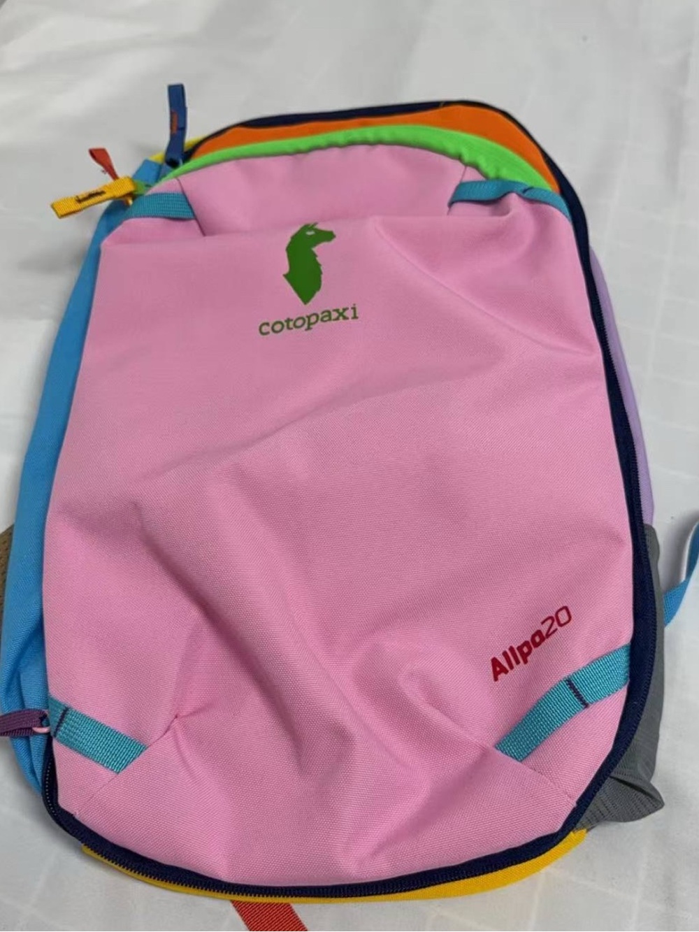 cotopaxi。backpack in pink with blue and green accents